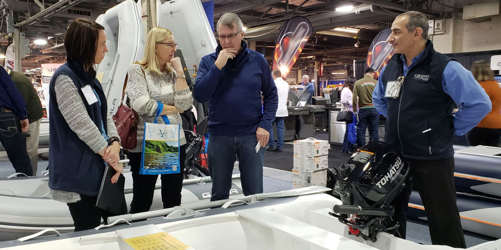 Sales team and customers at the Toronto International Boat Show looking at a aluminum rigid inflatable boat